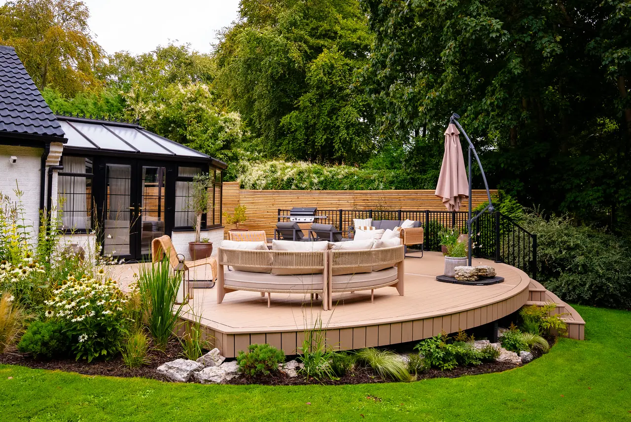 A raised, curved Trex Transcend Lineage deck in Carmel, set into planting beside the house