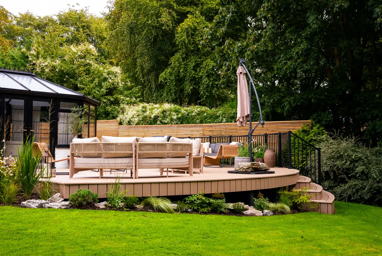 A curved Trex Transcend Lineage deck in Carmel across the lawn, with curved steps and black railing