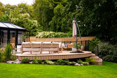 A curved Trex Transcend Lineage deck in Carmel across the lawn, with curved steps and black railing