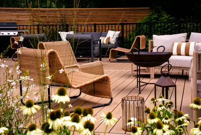 Lounge chairs and lanterns on a Trex Transcend Lineage deck in Carmel, flowers in front