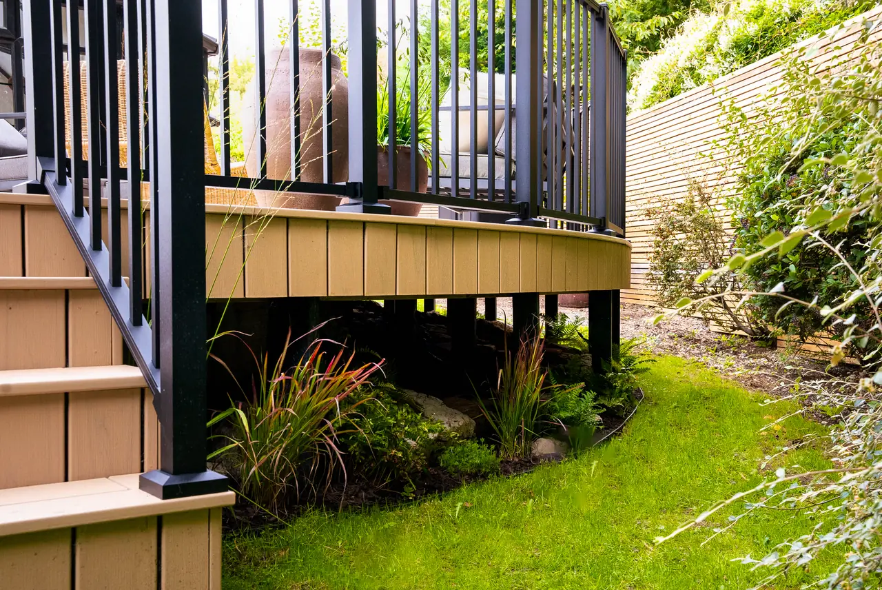 Steps and black railing down from a raised Trex Transcend Lineage deck in Carmel to the lawn