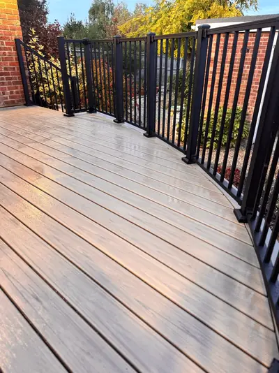 Black railing following the curved edge of a composite deck