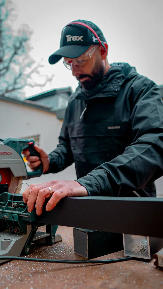 Darren in a Trex cap cutting a board on a mitre saw