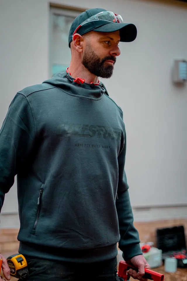 Darren standing on site in a work hoodie