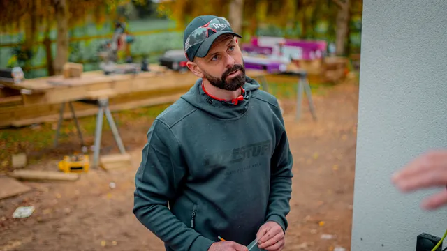 Darren on site beside a timber workbench