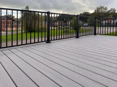 A Trex Enhance deck in Rocky Harbor with black railing, lodges beyond