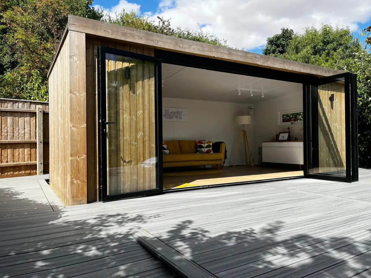 A garden room with glazed doors open onto a sunny deck