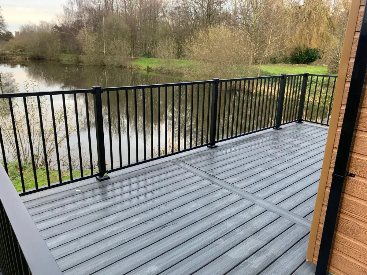 A raised deck with black railings looking out over a river