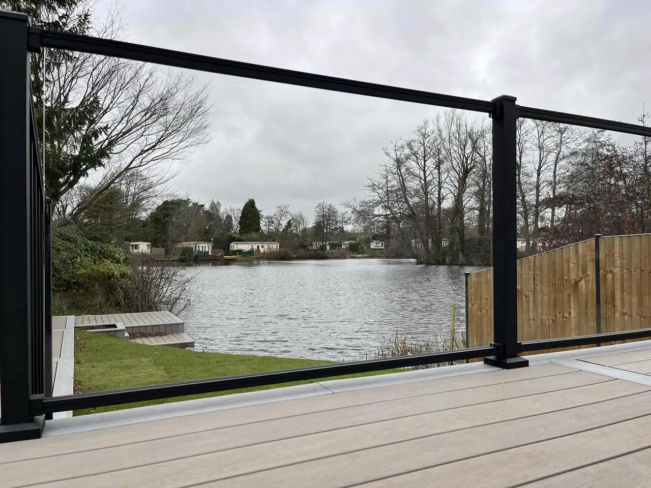 Black-framed glass railing on a deck, looking out over a lake
