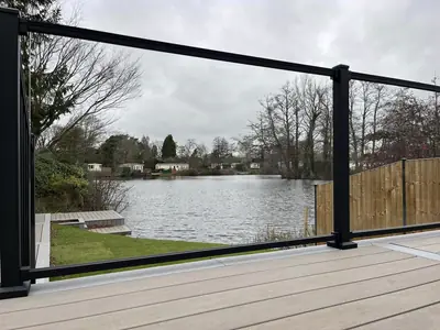 Black-framed glass railing on a deck, looking out over a lake