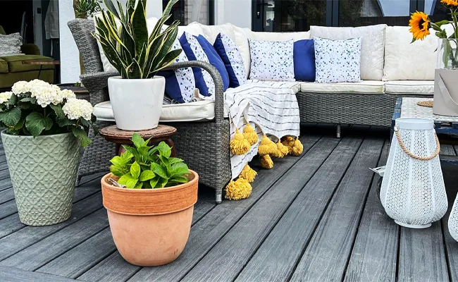 Trex Enhance boards under an outdoor sofa, potted plants and a lantern (photo: Trex)