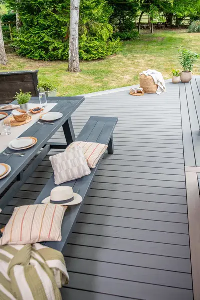 A long table on a grey Trex Transcend deck running out towards the lawn