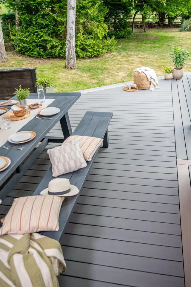 A long table on a grey Trex Transcend deck running out towards the lawn