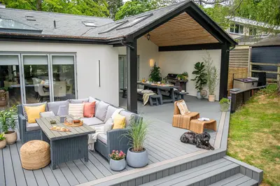 A covered lounge on a grey Trex Transcend deck, sofas and a low table under the roof