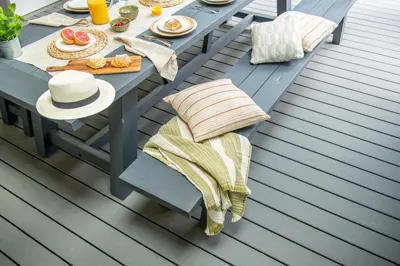 Cushions on benches at a long table on a grey Trex Transcend deck