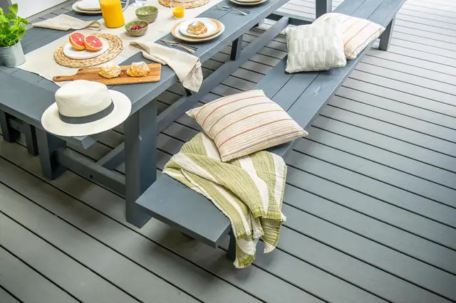 Cushions on benches at a long table on a grey Trex Transcend deck