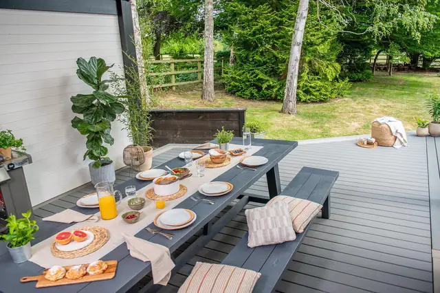 A dining table and benches on a grey Trex Transcend deck